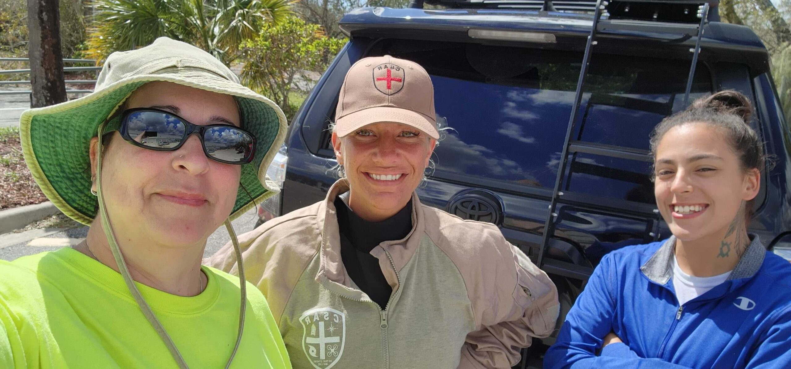 HelpNow volunteer team members smiling together in front of a response vehicle